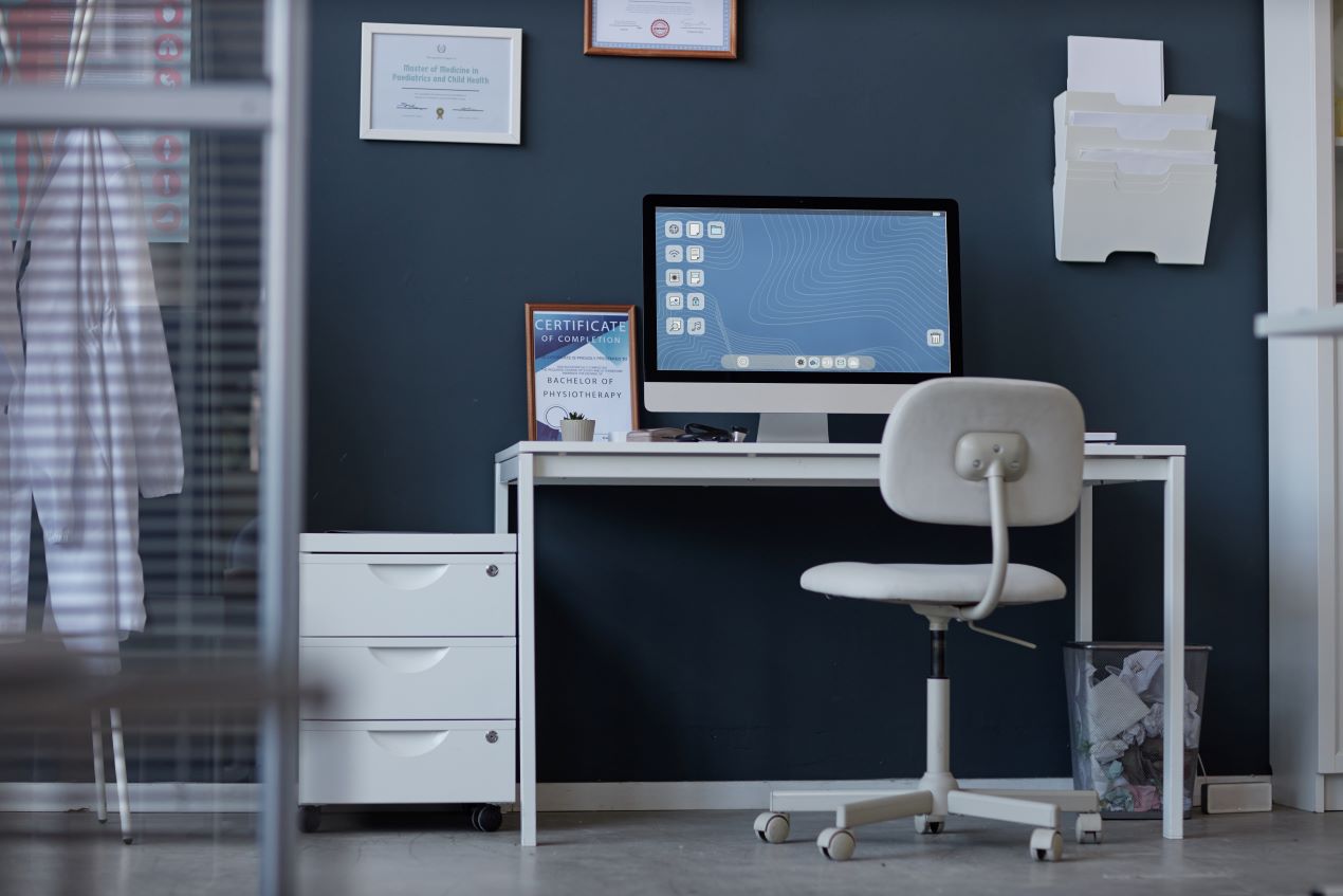 Ergonomischer Schreibtisch mit Computer in einer modernen Arztpraxis – funktionale Praxiseinrichtung für effizientes Arbeiten.