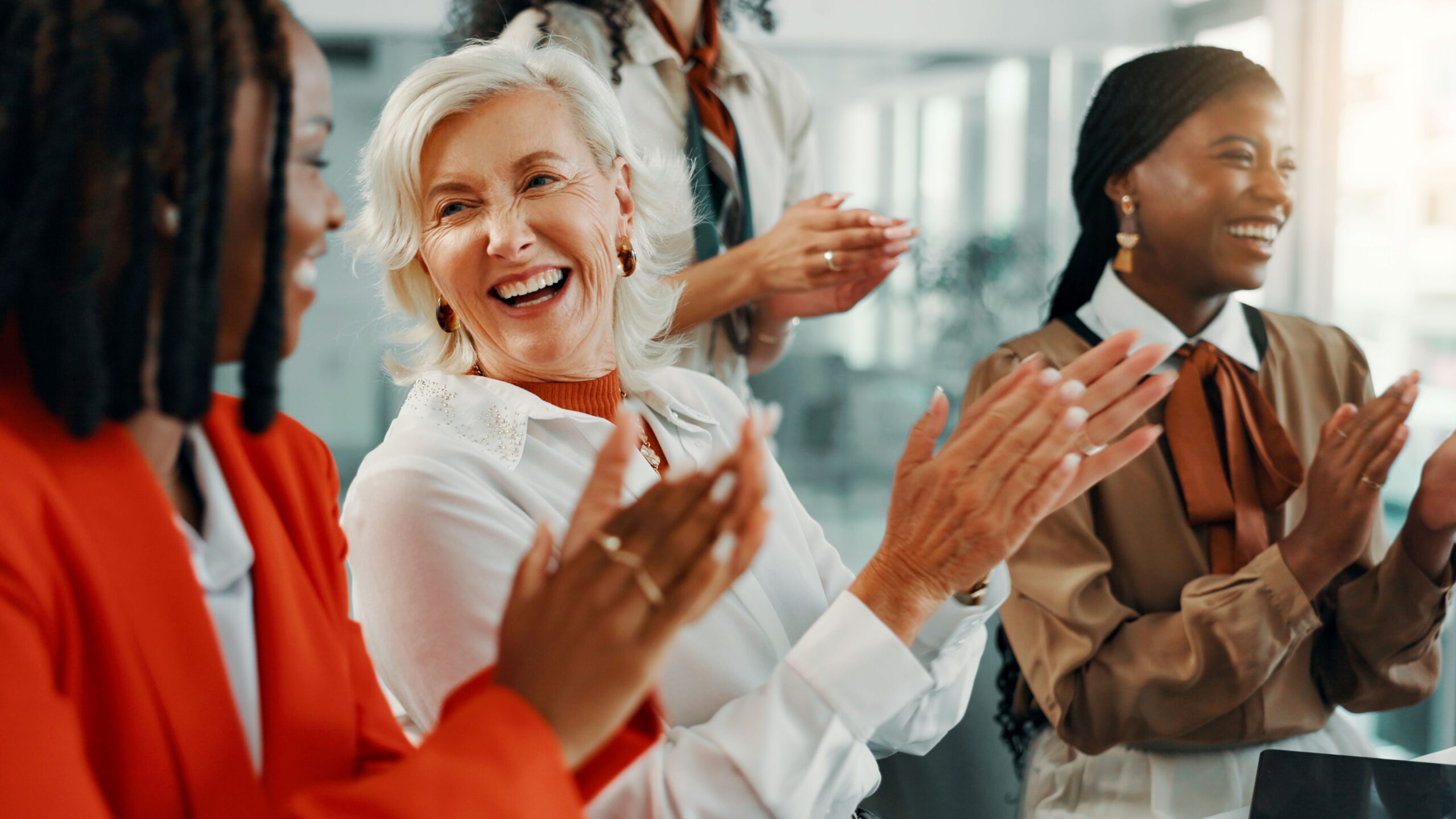 Zauberer Firmenfeier – Kolleginnen lachen und klatschen gemeinsam bei inspirierendem Eventmoment